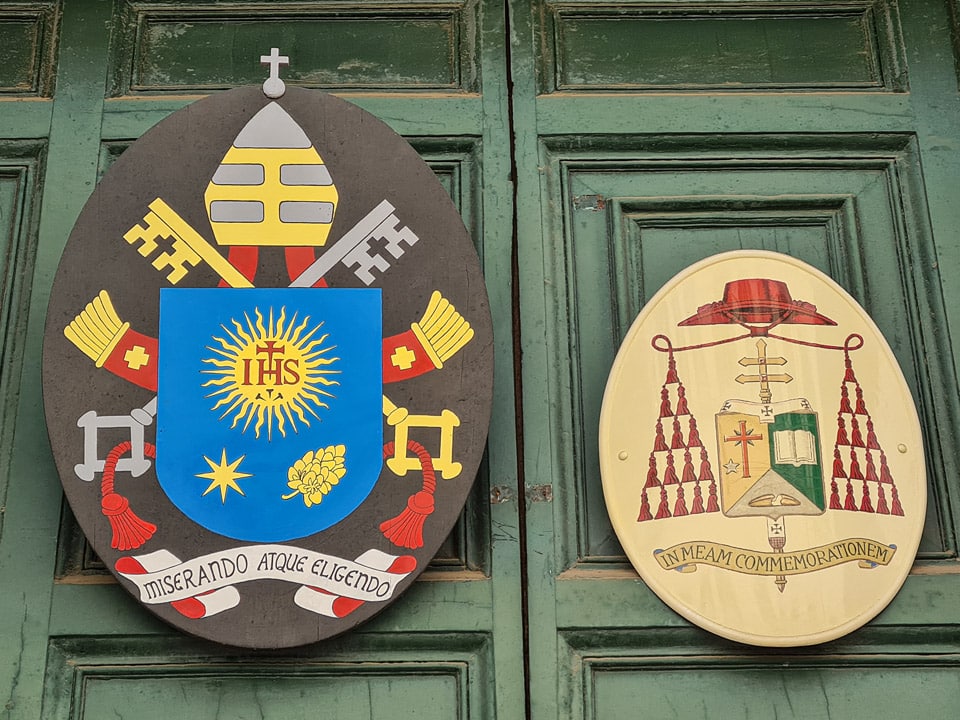 Herb papieża Franciszka oraz tablica należąca do kardynała Odilo Pedro Scherera