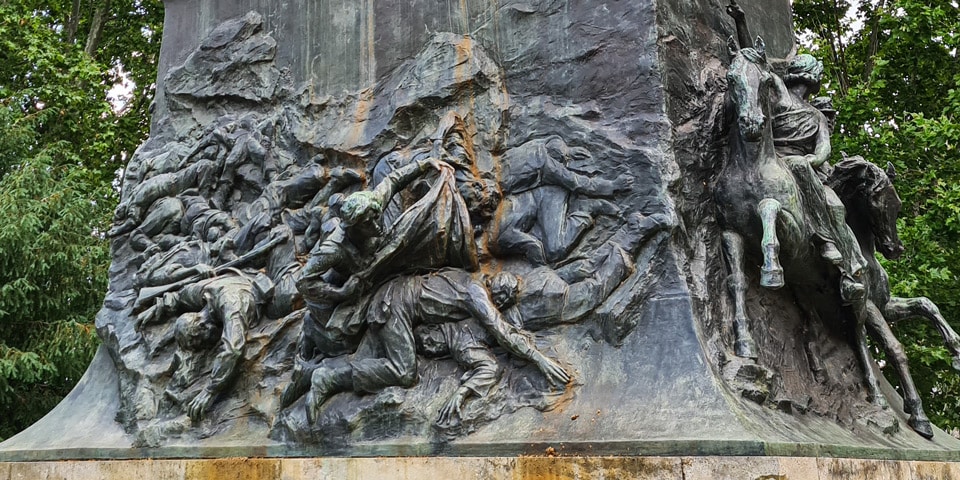 Brązowa płaskorzeźba przedstawiająca Anitę Garibaldi szukającą wśród poległych po bitwie pod Curitibanos
