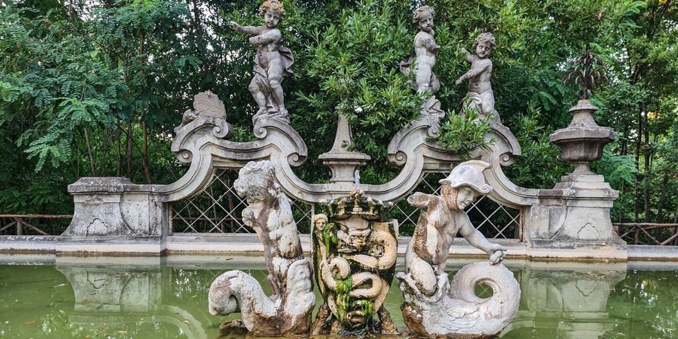 Putti, delfiny i ukoronowany biscione Viscontich na Fontannie Putti w Villa Sciarra