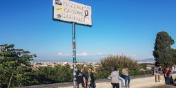 Piazzale Giuseppe Garibaldi street sign with tourists at the Janiculum viewpoint, Rome