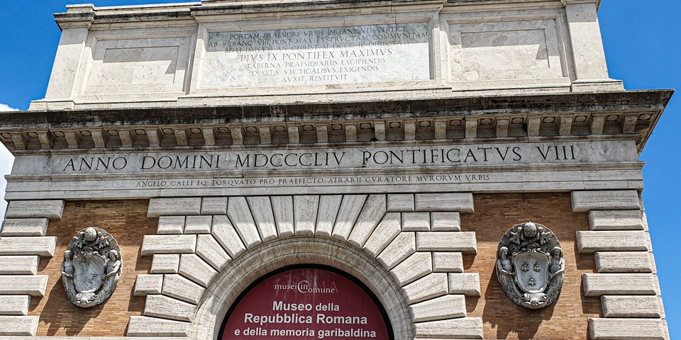 Łacińskie inskrypcje i herby papieskie na Porta San Pancrazio